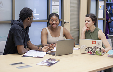 Students at a Table with open laptop