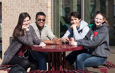 Students at a red, round picnic table