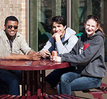 Students at a red, round picnic table