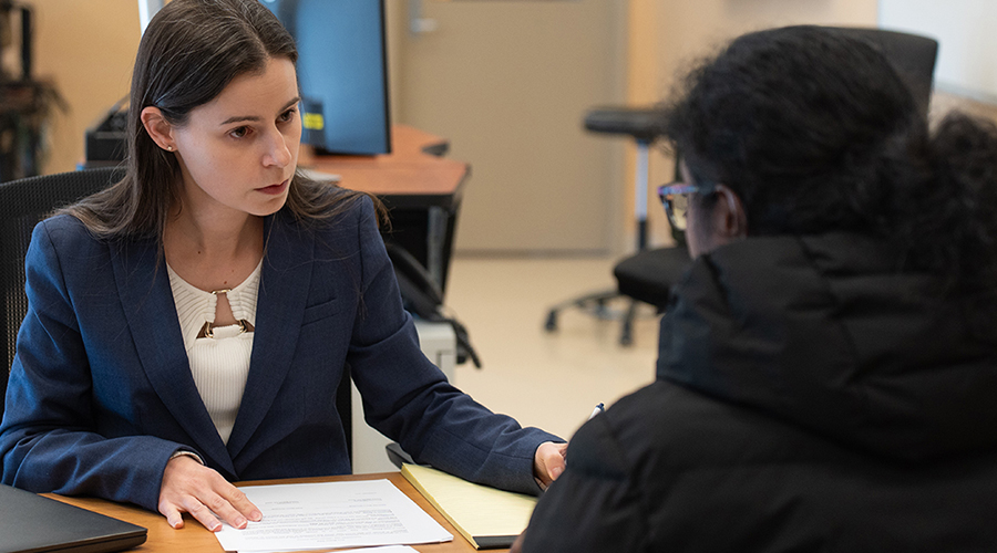 woman in suit helping woman across table