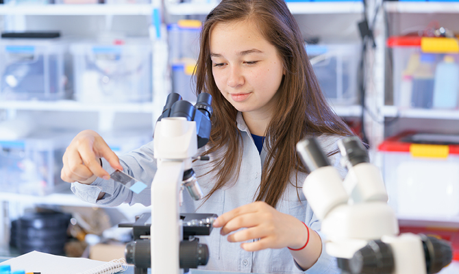 woman looking in microscope