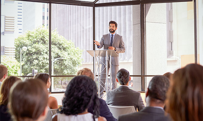 man at podium giving lecture