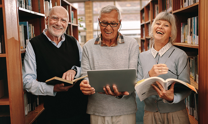 3 people with books in a library