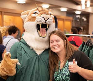 woman poses with Freddie Cougar mascot